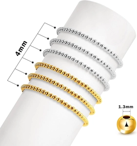 Detail of 4mm gold and silver spacer beads showing 1.3mm hole size for jewelry making