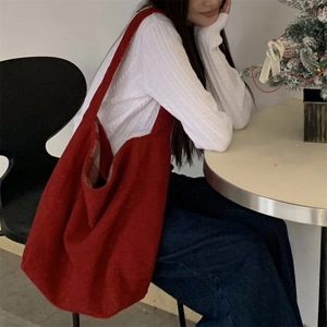 Detail of red wool knit tote bag for women shown in a cozy festive holiday setting