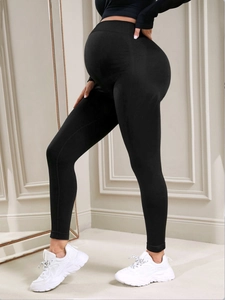 Detail of high-waisted seamless maternity leggings with supportive belly band and lifting effect