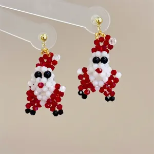 Close-up of handmade beaded Santa Claus earrings with red white and black crystal beads