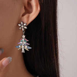 Close-up of pearl and colorful gemstone snowflake and Christmas tree earrings on model