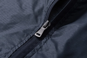 Macro shot of durable ripstop fabric and metal zipper detail on navy blue jacket
