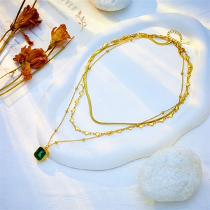 Three-layer gold snake chain necklace set with heart sequins and emerald square pendant