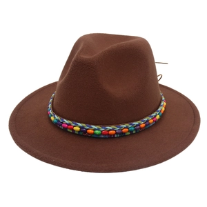 Détail d'une bande tissée ethnique colorée avec perles sur un chapeau fedora marron