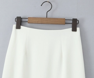 Detail shot of the waistband on a white woven pencil skirt with professional stitching