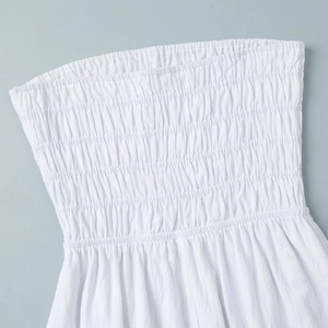 Close-up of elastic smocked cotton fabric on white strapless summer dress with pleated texture
