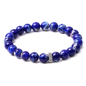 Macro shot of dark blue marble beads bracelet featuring a silver engraved metal charm bead