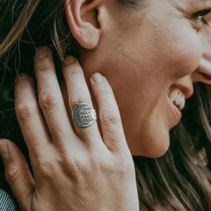 Bohemian style crescent moon ring with stay wild moon child engraving on a model's finger