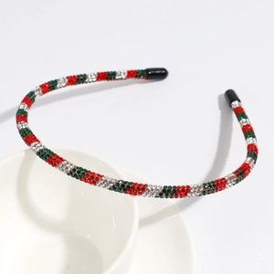 Detailed view of red and green rhinestone headband with protective black tips on ends