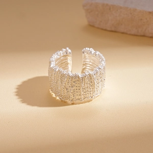 Macro detail of the silver geometric open ring featuring a unique lava texture finish