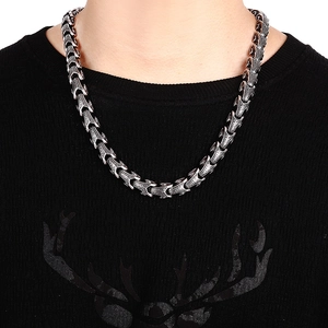 Close-up of a silver 316L stainless steel dragon bone chain necklace on a male model