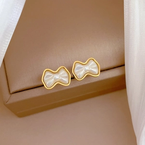 Titanium steel bow stud earrings with white pearl luster and elegant golden plating