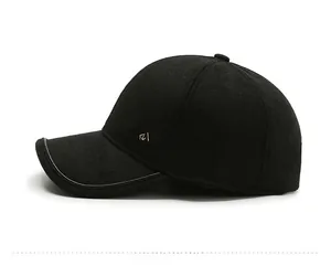Detail view of black wool baseball cap with leather brim edge and gold side logo