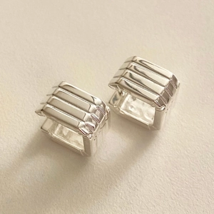 Macro shot of 925 sterling silver square stud earrings with parallel grooved lines