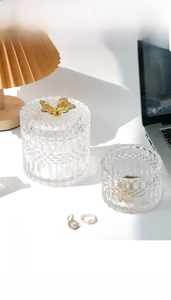 Close-up of vintage embossed glass storage jar with a gold butterfly ornament lid