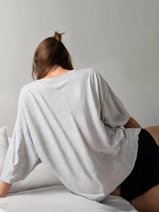 Λεπτομερής υφή γκρι βαμβακερού T-shirt που δείχνει την ποιότητα και τη χαλαρή γραμμή
