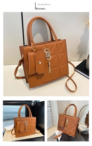 Detail of brown crossbody bag with geometric triangle texture and matching charm pouch
