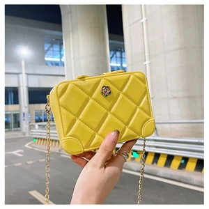 Detail of yellow PVC jelly bag with quilted pattern, gold chain and floral metal clasp
