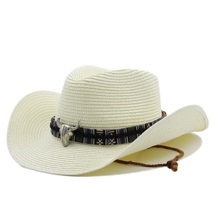 Detail of summer cowboy straw hat with ethnic band and silver bull head ornament