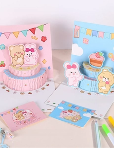 Detailed view of 3D pop-up birthday cards featuring cute bear and rabbit cake designs