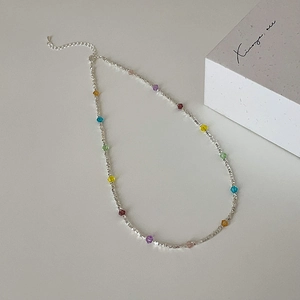 Detailed macro view of colorful crystal beaded necklace with silver metal beads and lobster clasp