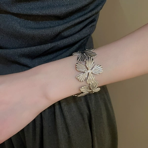 Dettaglio macro del bracciale a fiori d'argento con petali di metallo e design floreale