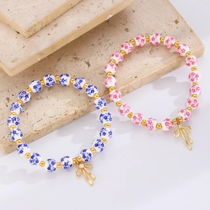 Braccialetti di perle in ceramica floreale con ciondolo a fiocco dorato su pietra