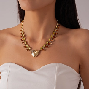 Close-up of vintage gold necklace with wheat-shaped crystals and amber leaf droplets