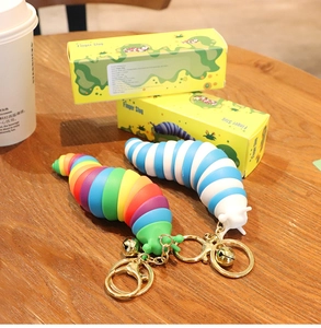 Rainbow and blue finger slug fidget toys with gold keychains and original packaging
