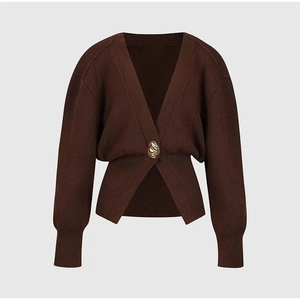 Detail of dark brown V-neck cardigan with gold button and ribbed lantern sleeves