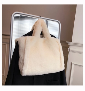 Détail d'un sac cabas en fausse fourrure pelucheuse blanc crème dans un décor épuré