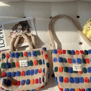 Plush bucket bag with colorful 3D pom-pom decorations and faux shearling texture