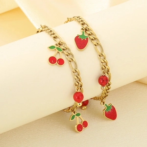 Detail of 18K gold-plated bracelets featuring red cherry and strawberry fruit charms