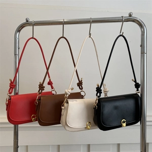 Minimalist leather saddle bag with gold metal clasp and knot strap in four stylish colors