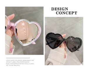 Detail of pink and black heart-shaped sunglasses featuring high-quality acetate frames