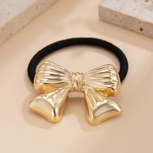 Golden metal bow hair tie with floral accents and textured surface for women