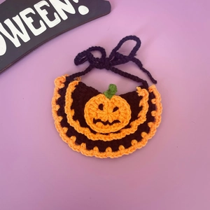 Detail van handgehaakte Halloween-halsband voor huisdieren met pompoen op paars decor