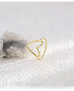 Macro view of gold minimalist hollow heart ring with elegant double-layered metal band