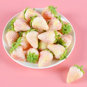 Realistic artificial white strawberries on white ceramic plate with soft pink background