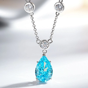 Macro shot of pear-shaped light blue gemstone pendant with sparkling silver plating