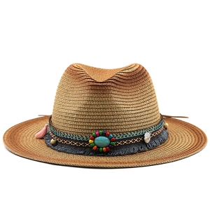 Detail of bohemian straw hat with turquoise beadwork and colorful tassel accents