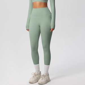 Detail view of light green high-waisted yoga pants featuring a practical side phone pocket