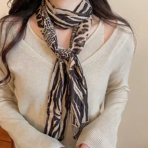 Elegant leopard and zebra print long scarf necklace with coffee tones on beige sweater