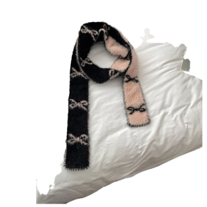 Chic skinny knit scarf with black and pink bow patterns on a soft white surface