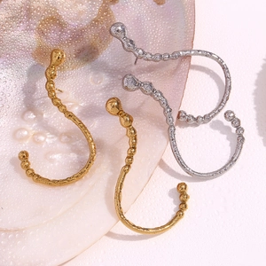 Detailed view of irregular beaded C-shape earrings in gold and silver finish