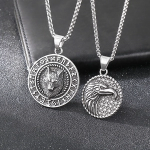 Detail of Viking wolf and eagle pendants with runes on black leather background