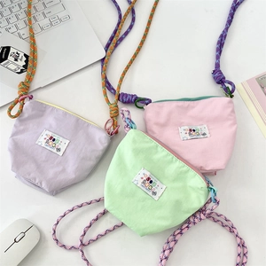 Overhead view of nylon crossbody phone bags in pastel purple, green, and pink colors