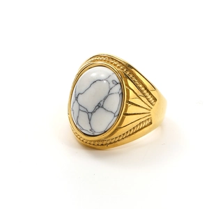 Detail of vintage gold ring featuring a large oval white gemstone with marble texture