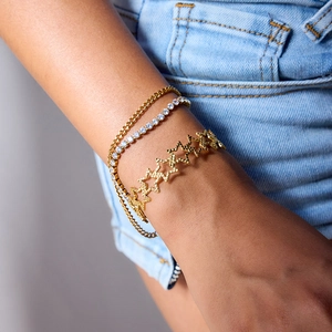 Close-up of layered 18K gold stainless steel star bracelet and zircon tennis chain set