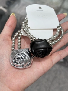 Detail of double-layer bead hair ties featuring metallic and matte leather rose charms